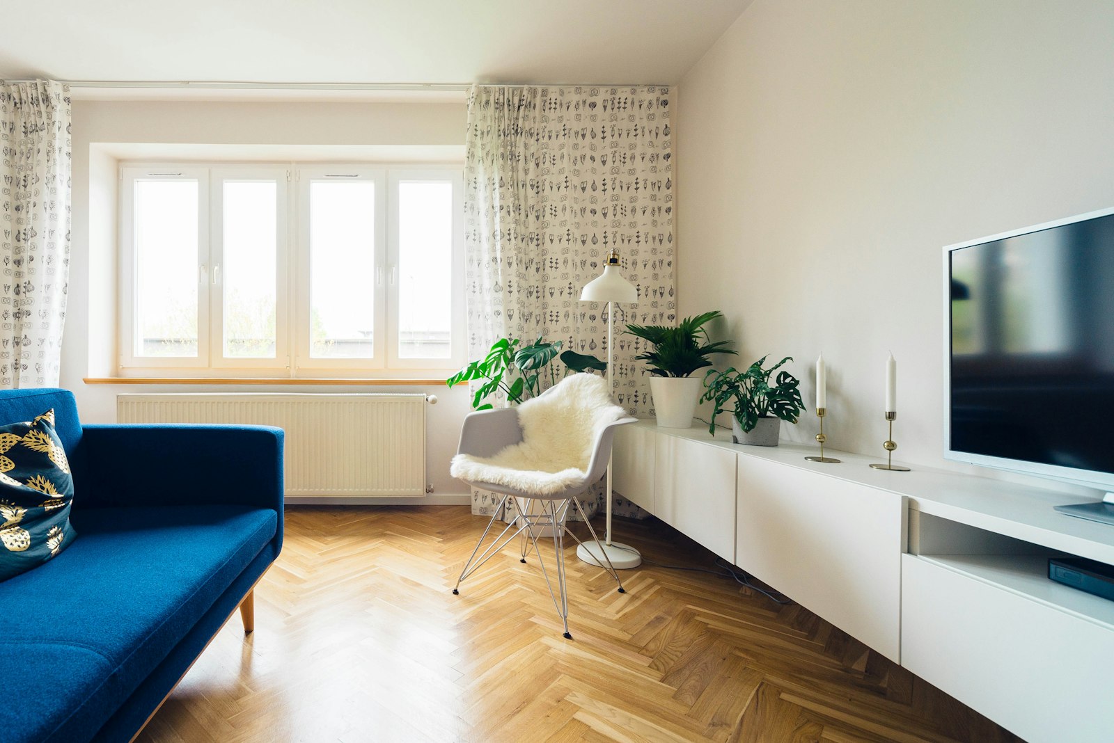 Sunlit living room with plants and a timber floor
